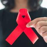 Woman holding red ribbon for World AIDS Day