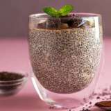 A glass of Chocolate-Peanut Butter Chia Pudding on pink background