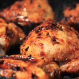 Grilled chicken pieces with char marks and glossy glaze