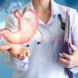 Image of a doctor holding a floating stomach in hand