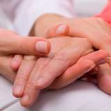 An older person's hand being held