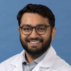 White coat head shot of Jason Gandhi, smiling at the camera
