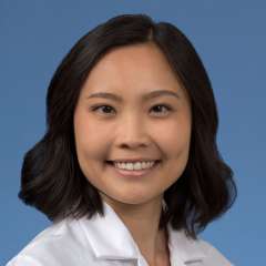 Head shot of Kristine Khieu in a white coat, smiling at camera