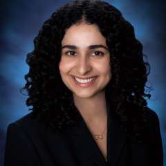 Dr. Nicki Karimi-Mostowfi in a black suit jacket smiling at the camera