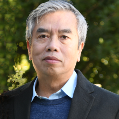 headshot of Hung Ton-That, PhD in an outdoor setting with leaves in the backgrounds