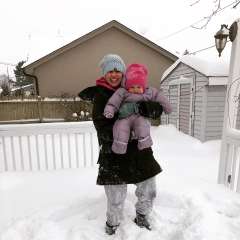 Stephanie-Dee Sarovich in the snow holding a baby