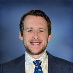Dr. Jacob Klickstein in a suit smiling at the camera