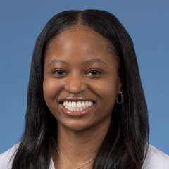 Head shot of Christina Ramsey in a white coat, smiling at camera