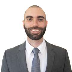 Nicholas Kopoosian in a business suit, smiling at camera