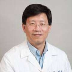 Otto Yang, portrait wearing a white lab coat and collared shirt.