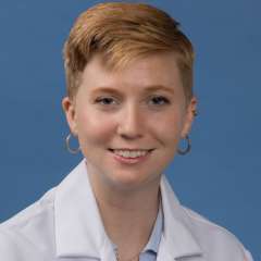 Head shot of Mallory Blackwood in white lab coat, smiling at camera