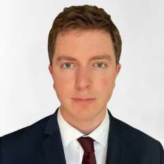 Head shot of Dylan Calame in business attire, looking at camera