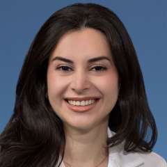Head shot of Natalie Nabaty, MD in white coat, smiling at the camera