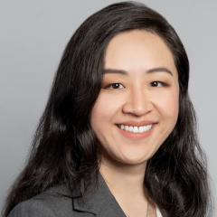 Head shot of Irma Zhang in business attire, smiling at camera.