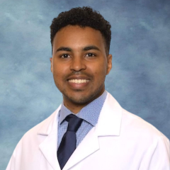 headshot of Dr. Ehab Bahrun wearing a lab coat in front of a blue background