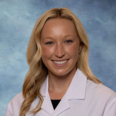 headshot of Dr. Andrea Antenucci wearing a white lab coat in an indoor setting with a blue background