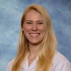 Dr. Fiona Roediger headshot smiling and wearing a white lab coat.