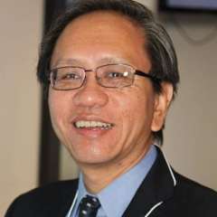 Headshot of Guy Soo Hoo, MD, smiling, in a dark suit and tie.