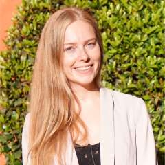 headshot of Rozeta Avetisyan with a bush plant in the background
