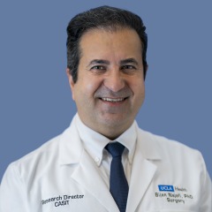 Dr. Bijan Najafi, PhD, wearing a white UCLA Health lab coat and smiling against a blue background.