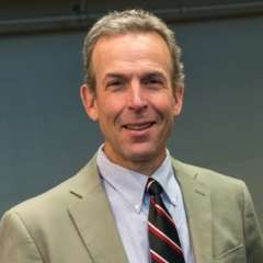 K. Christopher Garcia in a suit and smiling