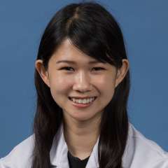 Head shot of Edith Yuan in white lab coat, smiling at camera