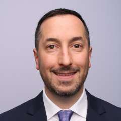 A man with short hair wearing a suit and tie