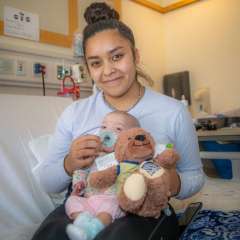 Patient with newborn patient and teddy bear