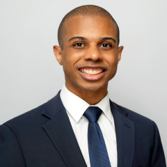 Head shot of Paul Lewis in a suit smiling at the camera