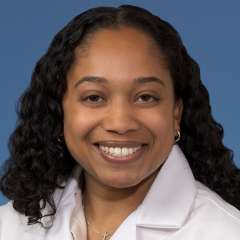 Head shot of Rehana Persaud, MD, MS in white coat, smiling at the camera