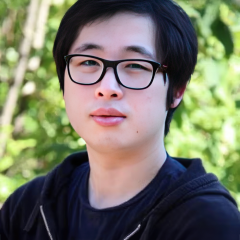 Zhiyuan Mao standing outdoors with greenery in the background.