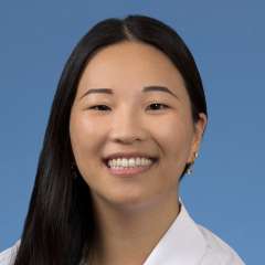 Head shot of Joyce Lee in a white coat, smiling at the camera