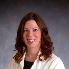 Jennifer A. Fulcher, MD, PhD in white lab coat, professional headshot
