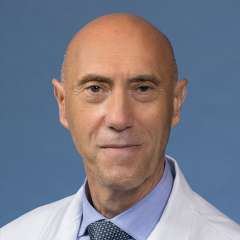 Nicola Longo, MD headshot wearing white coat, blue shirt and patterned tie