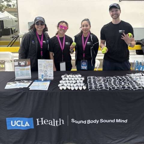 Four interns stand behind table with UCLA Health Sound Body Sound Mind