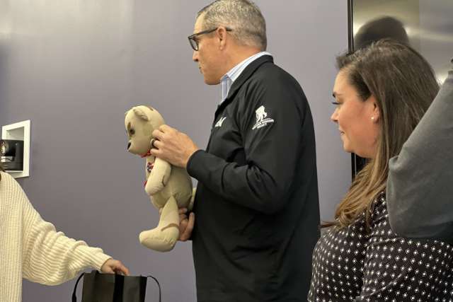 Gen. Michael Linnington holds an Honor Bear. April Sabin, Operation Mend program director, is on his right. 